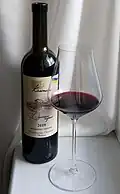 A bottle and a glass of red wine