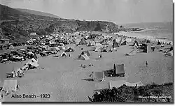 Black and white photograph of a beach covered in tents