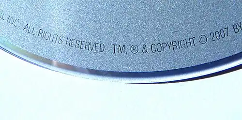 Text engraved on a DVD: ...ALL RIGHTS RESERVED, TM, ® & COPYRIGHT © 2007 BY...