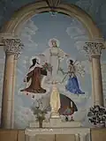Interior of the church. Painting depicting the Virgin Mary with Saint Thérèse of Lisieux and Saint Joan of Arc at her sides.