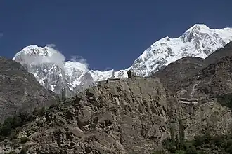 A view of the Altit Fort taken from the Karakoram Highway, Pakistan. In the background, snow-covered Hunza peak is seen.