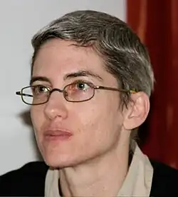 Head shot of Amal Ziv. Very short graying hair. Looking to the side of the camera.