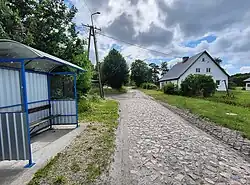 Bus stop, farm building and road in the tiny settlement of Ameryka.