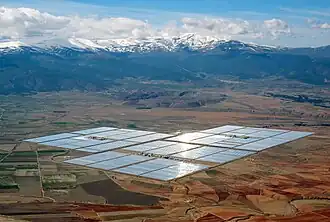 Concentrated solar power parabolic troughs in the distance arranged i