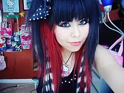 Image 19A teenage American scene girl in 2011, wearing raccoon-striped hair extensions, heavy eyeliner, and colorful accessories typical of the style. (from 2010s in fashion)