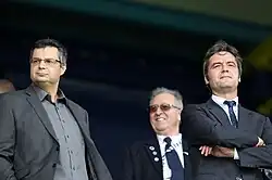 Three men in suits looking forward