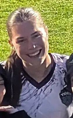 Smiling player in uniform taking photo with supporters
