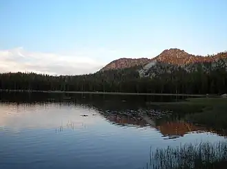 Early morning or evening photo of the lake reflecting a mountain.