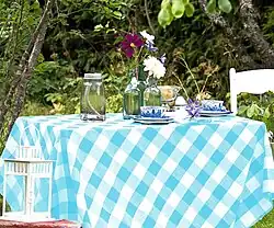Aqua blue and white plaid cotton tablecloth on an outdoor table