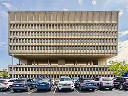 Western elevation of the facade, with a parking lot in front