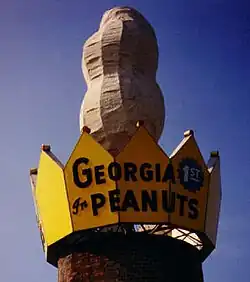 A giant peanut surrounded by a yellow crown on which is written "Georgia First In Peanuts"
