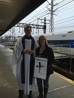 A priest has an "Ashes to Go" station for commuters at a train station.