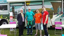 Staff from Senedd Cymru pose outside their outreach bus at Swansea Pride in July 2013