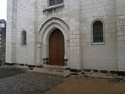 Color photograph of a church facade with large brown stones at ground level