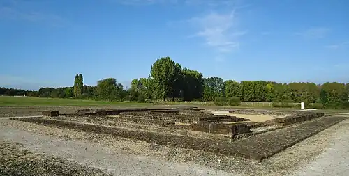 Color photograph of the base of two ancient walls representing two concentric enclosures.
