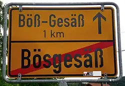 A german city sign of "Bößgesäß", with the reference to Böß-Gesäß, one kilometer (1000 yards) away.