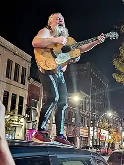 Johnston playing outside Toronto's Bovine Sex Club on top of his van in 2024.