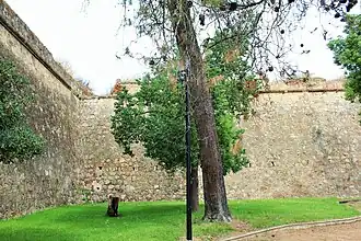 Inward-angled curtain wall with arrowslits and embrasures
