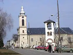 Street in Bajmok, the Catholic Church (right), and bell-tower of the Orthodox church (left)