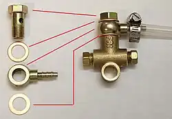 An example of typical banjo fitting components (left) with an identical fitting connecting a hose to a tee fitting.