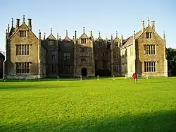 Three bay house with multiple windows, pinnacles and chimneys