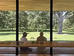 Photo of two people sitting on a bench looking at trees