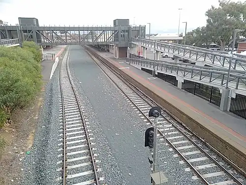 View of the station platforms and pedestrian footbridge looking south
