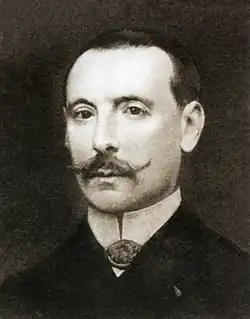 Black and white portrait of a man with a thin mustache.
