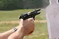 Beretta M9 semi-automatic pistol exhibiting muzzle rise just after firing a 9×19mm Parabellum cartridge.