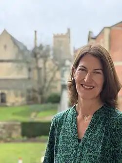 A headshot of Beth Breeze with Harris Manchester College in the background
