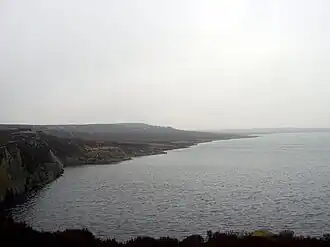 A lake with a rocky shoreline