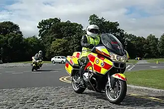 Two motorbikes on a road, both with the same red and yellow livery