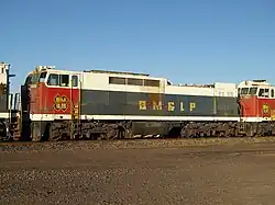 Broadside view of a boxy red, white, and black locomotive