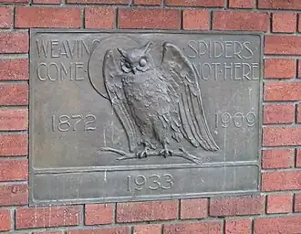Plaque showing an owl, the moon, and text