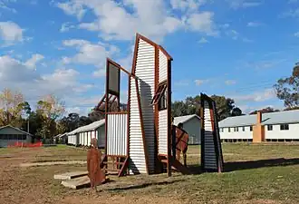 Sculpture at the migrant camp. Some of the buildings that once housed migrants can be seen in the background.