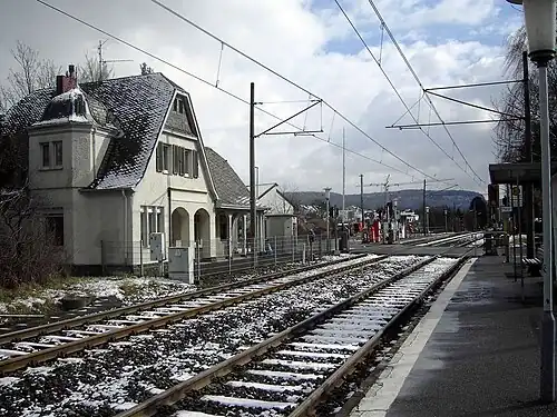 Snow-covered double-tracked railway line surrounded by platforms
