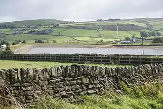 Fields ribboned with stone walls with a reservoir in the middle-distance and hills in the far distance