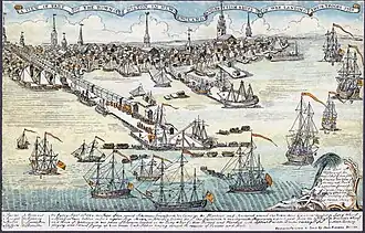 A wide view of a port town with several wharves. In the foreground there are eight large sailing ships and an assortment of smaller vessels. Soldiers are disembarking from small boats onto a long wharf. The skyline of the town, with nine tall spires and many smaller buildings, is in the distance. A key at the bottom of the drawing indicates some prominent landmarks and the names of the warships.