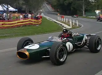 A green cigar-shaped racing car with exposed wheels and an open cockpit. The number one is painted on the nose and sides.