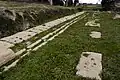 The series of slotted bases in the building north of the stoa