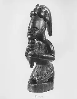 African figurine of kneeling figure holding a rod
