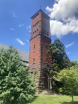 red brick building with tower surrounded by trees