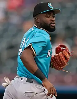 Bryan Ramos of the Charlotte Knights wearing a uniform, hat, and glove, running away from the camera