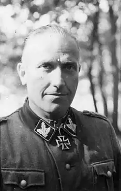 Black-and-white portrait of a man wearing a military uniform with an Iron Cross displayed at his neck.