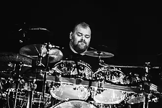 black-and-white image of Piotr Kozieradzki playing a drumkit onstage