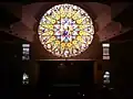 View of the 16-paneled stained glass window, created by Joël Mône and realized by Vitrail Saint-Georges, from the third level of church building.