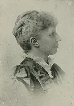 B&W side view portrait photo of a middle-aged woman with her hair in an up-do.