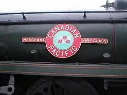 A Merchant Navy class enamelled metal nameplate mounted on the side of the locomotive boiler. The nameplate comprises a circle, containing a picture of the company flag of the shipping line, and two rectangles on either side containing the class name. In a larger circle bordering the central flag is the name of the shipping line.