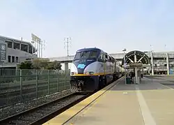 A diesel locomotive at a surface-level railway station