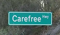 A green road sign reading 'Carefree Hwy'.